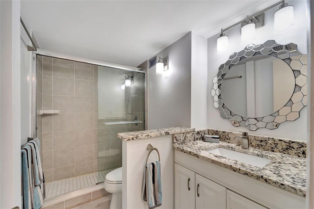 5855 Midnight Pass Road, Unit 314 Sarasota, FL 34242 - Photo 28 of 58 a bathroom with a granite countertop sink toilet and shower