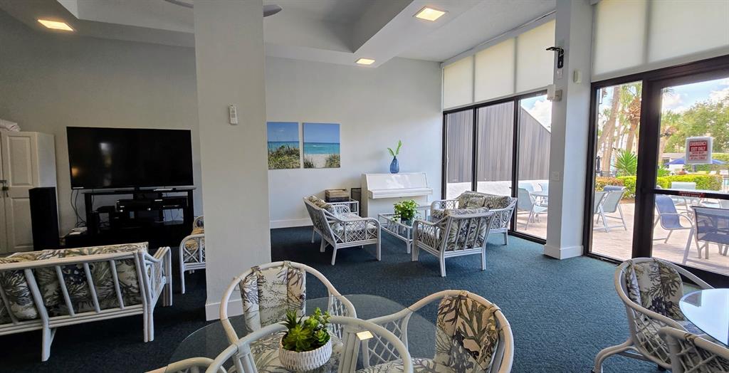 5855 Midnight Pass Road, Unit 314 Sarasota, FL 34242 - Photo 41 of 58 a dining room with furniture a flat screen tv and a floor to ceiling window