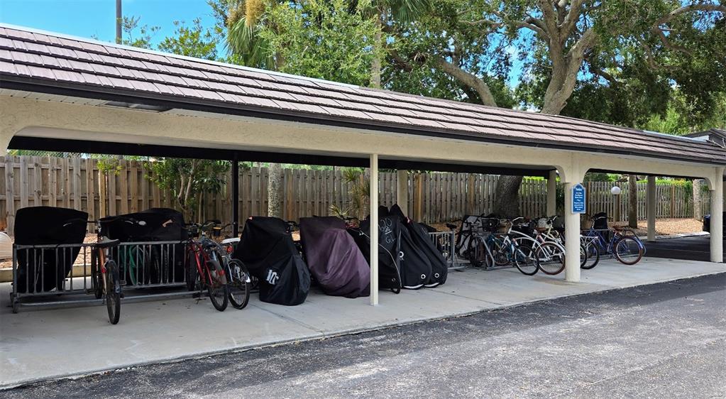 5855 Midnight Pass Road, Unit 314 Sarasota, FL 34242 - Photo 57 of 58 a view of a patio with table and chairs under an umbrella