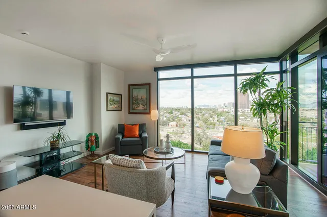 a living room with furniture kitchen view and a large window