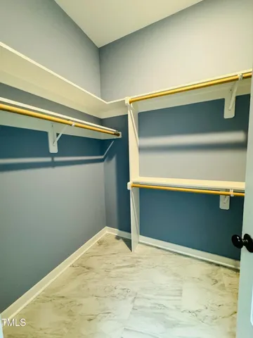 a view of a hallway with wooden floor and a bathroom