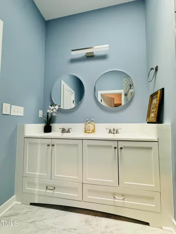 a bathroom with a toilet sink vanity granite and mirror