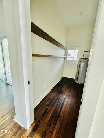 a large kitchen with cabinets stainless steel appliances a sink and wooden floor