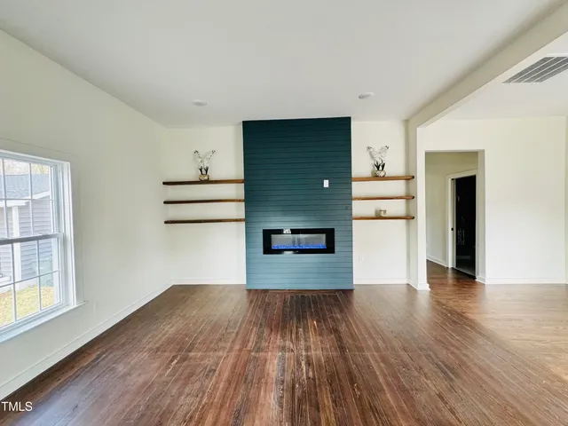 a view of empty room with wooden floor