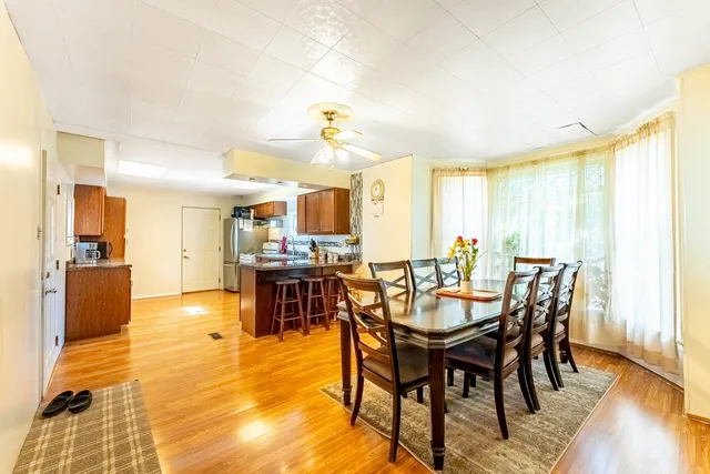 a kitchen with stainless steel appliances granite countertop a stove a sink dishwasher and a refrigerator with wooden floor