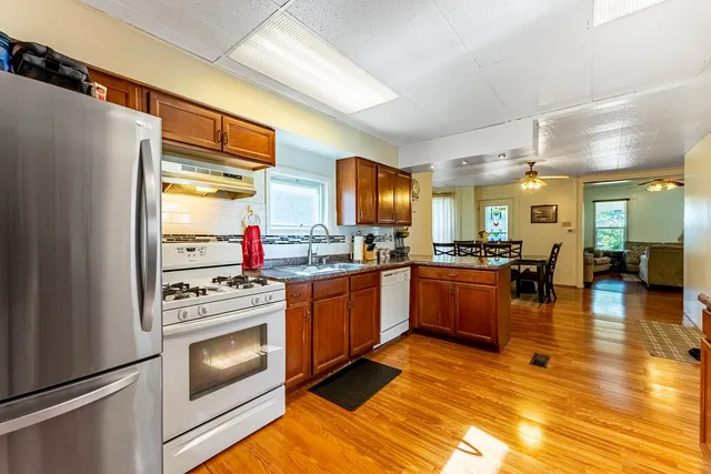 a kitchen with stainless steel appliances granite countertop a sink counter space cabinets and a large window