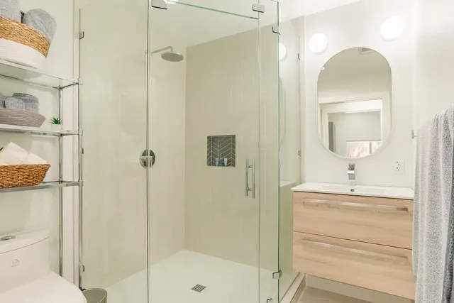 a bathroom with a shower a mirror and a sink