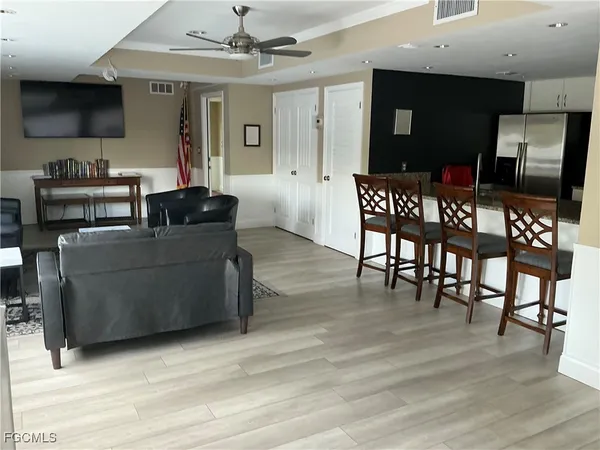 a living room with furniture a table and kitchen view