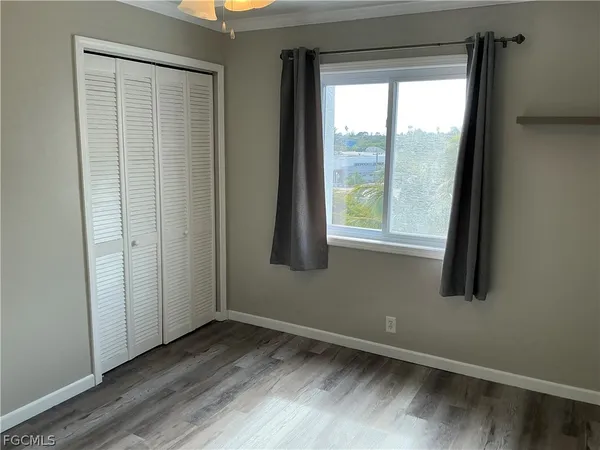 a view of a room with wooden floor fan and windows