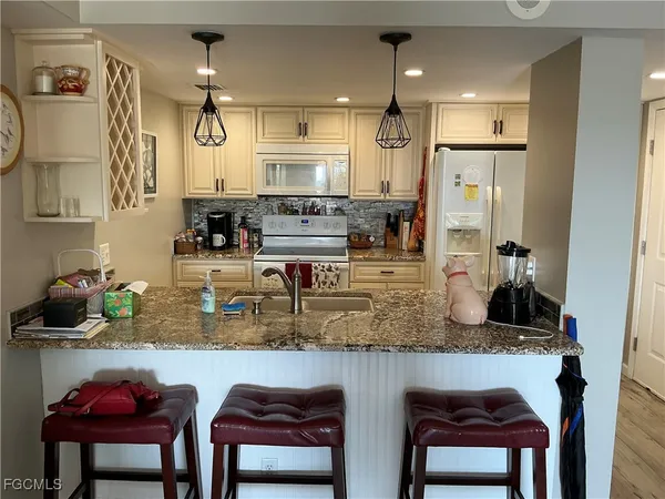 a kitchen with stainless steel appliances granite countertop a refrigerator and a stove