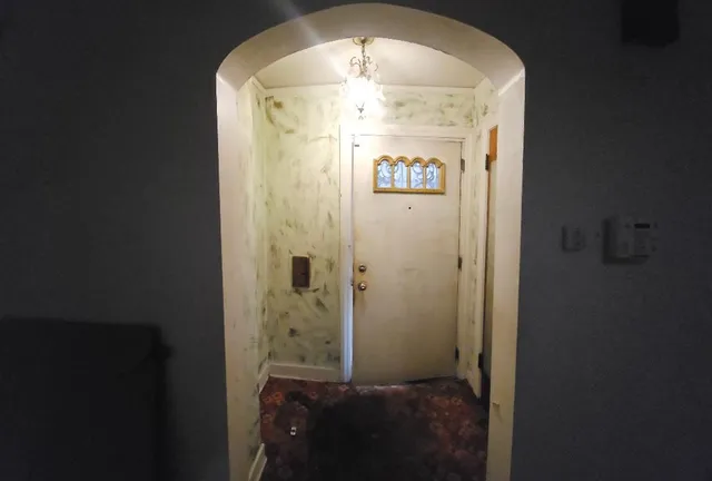 a view of an empty room with a fireplace and a window