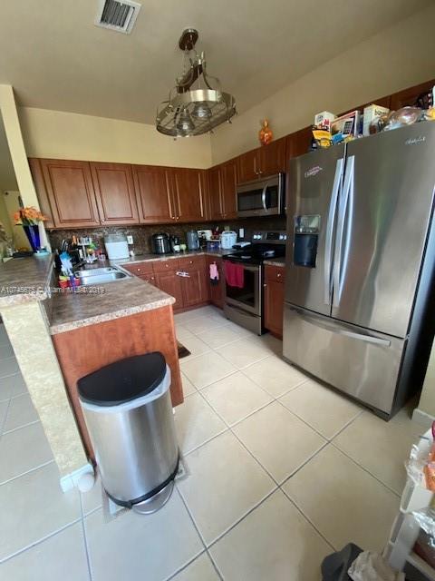 12999 Southwest 132nd Terrace, Unit 12999 Miami, FL 33186 - Photo 11 of 23 a kitchen with a sink a refrigerator and chairs