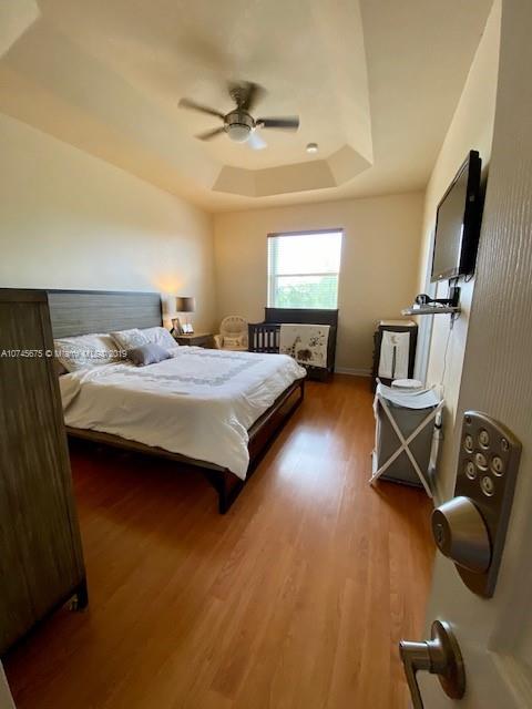 12999 Southwest 132nd Terrace, Unit 12999 Miami, FL 33186 - Photo 14 of 23 a bedroom with a bed and a flat screen tv