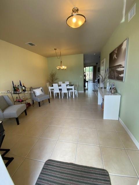 12999 Southwest 132nd Terrace, Unit 12999 Miami, FL 33186 - Photo 2 of 23 a living room with furniture and a flat screen tv