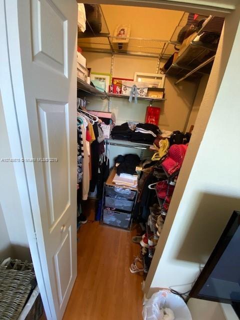 12999 Southwest 132nd Terrace, Unit 12999 Miami, FL 33186 - Photo 21 of 23 a view of walk in closet with clothes and shoes
