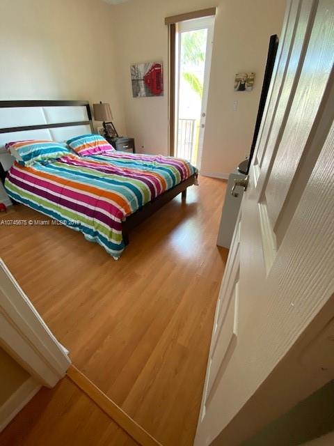 12999 Southwest 132nd Terrace, Unit 12999 Miami, FL 33186 - Photo 22 of 23 a bedroom with a bed and wooden floor