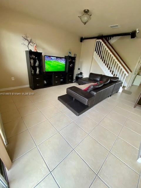 12999 Southwest 132nd Terrace, Unit 12999 Miami, FL 33186 - Photo 5 of 23 a living room with hard wood flooring and a table