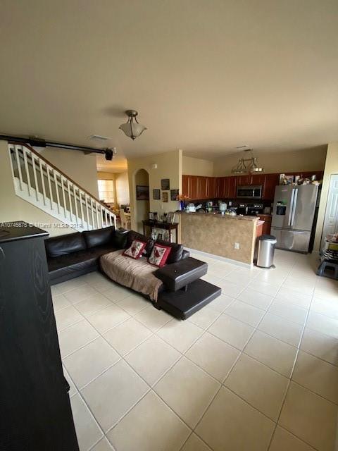 12999 Southwest 132nd Terrace, Unit 12999 Miami, FL 33186 - Photo 7 of 23 a living room with furniture and a chandelier