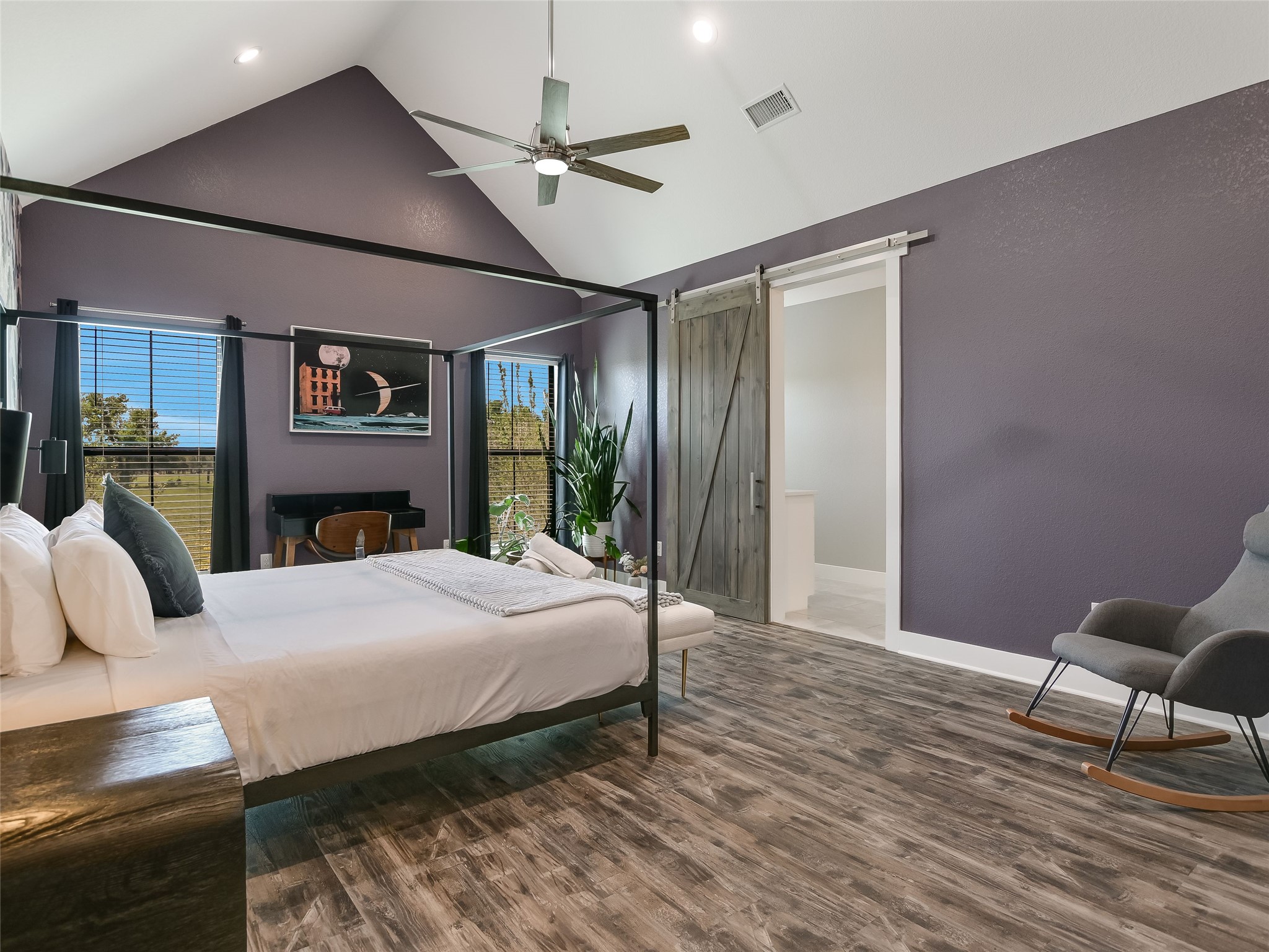 19819 Lockwood Road Manor, TX 78653 - Photo 11 of 29 The spacious primary retreat features vaulted ceilings, bold wall tones, and a sliding barn door that adds rustic flair to the modern design.