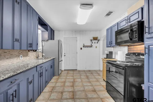 a kitchen with stainless steel appliances granite countertop a stove top oven a sink and dishwasher
