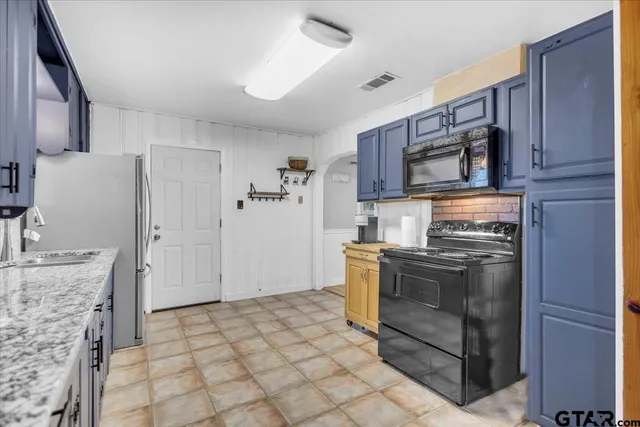 a kitchen with stainless steel appliances granite countertop a refrigerator stove and sink