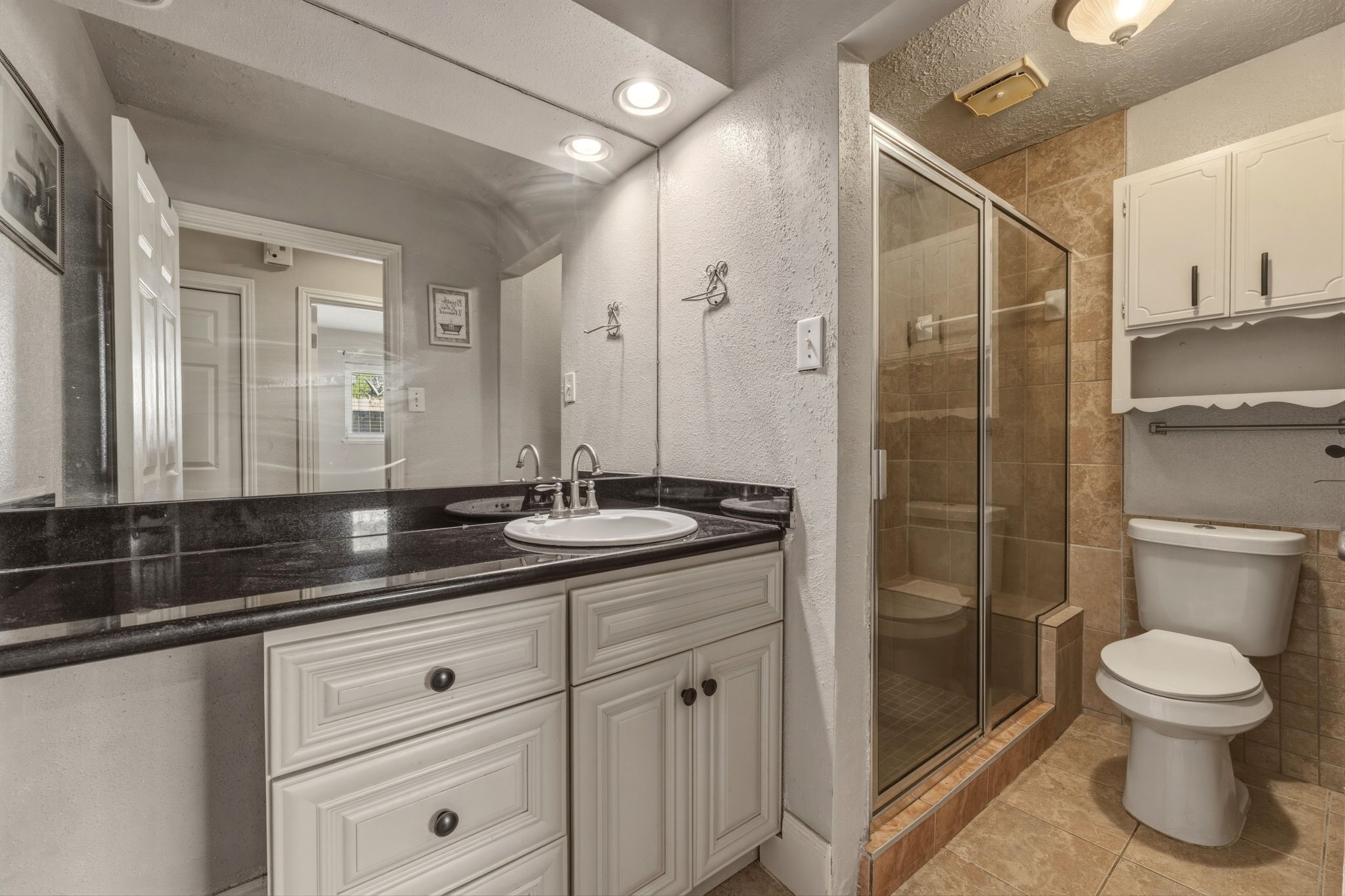 5211 Court Road Houston, TX 77053 - Photo 19 of 35 a bathroom with a granite countertop sink a toilet and a shower