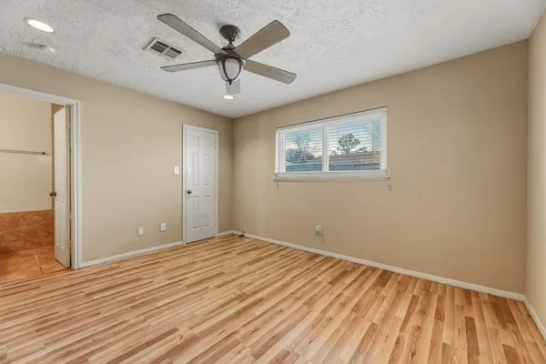 a view of empty room with wooden floor