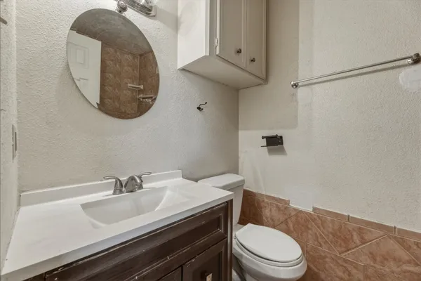 a bathroom with a sink a toilet and a mirror