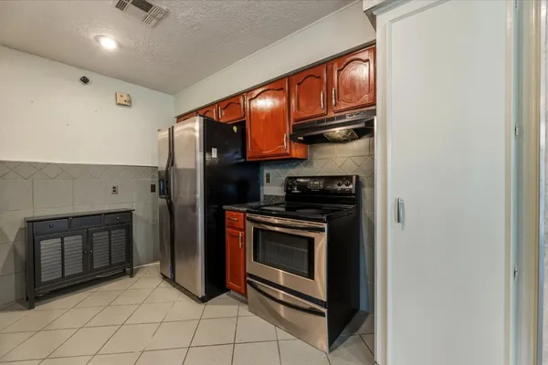 a kitchen with stainless steel appliances granite countertop a stove and a refrigerator