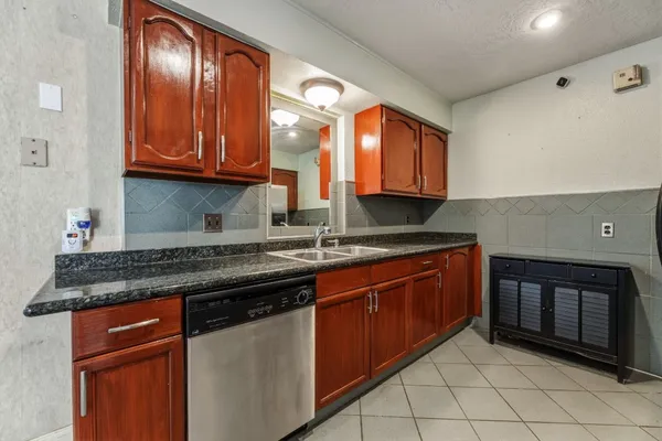 a kitchen with stainless steel appliances granite countertop cabinets and window