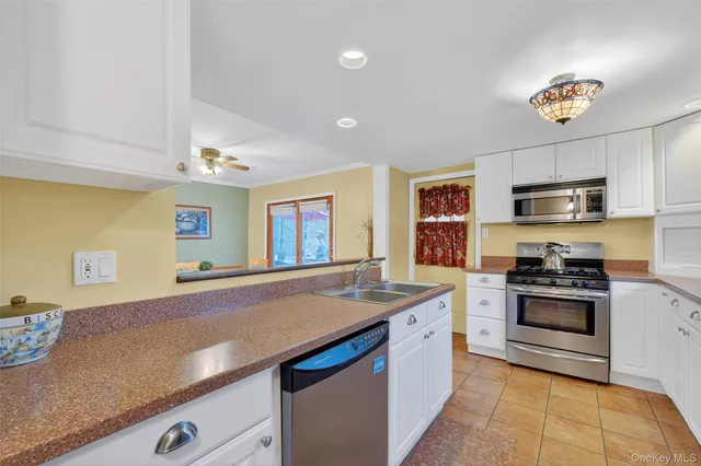 a kitchen with stainless steel appliances granite countertop a sink and a stove