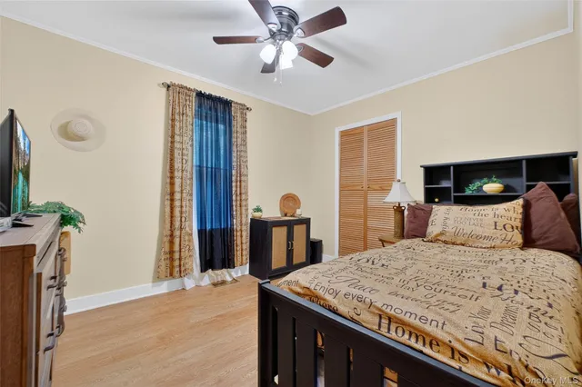 a bedroom with a large bed and a flat tv screen on dresser