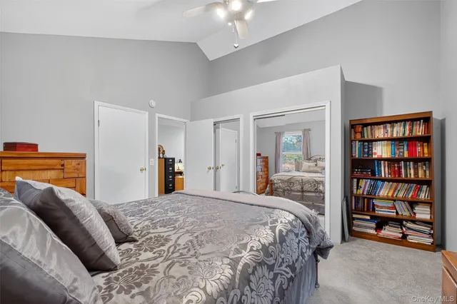 a bedroom with a large bed and a book shelf