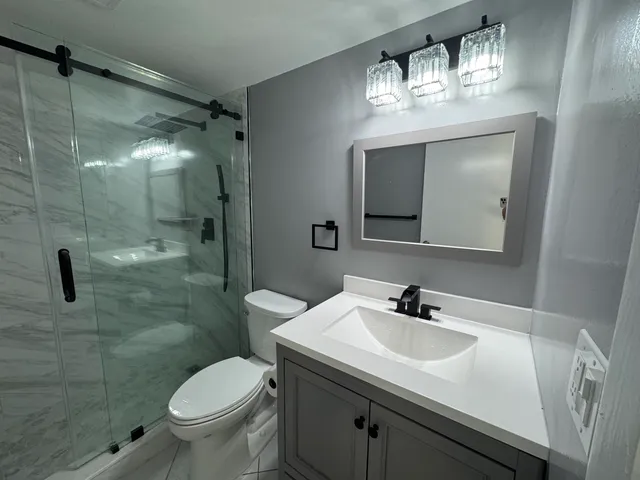 a bathroom with a sink toilet and shower