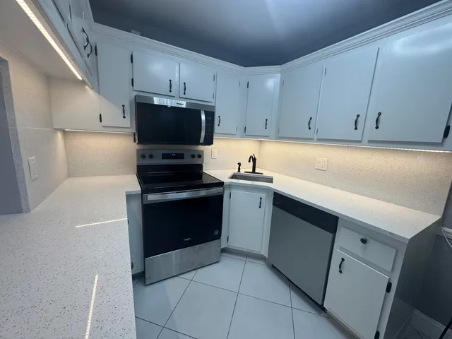 a kitchen with a sink a stove and cabinets