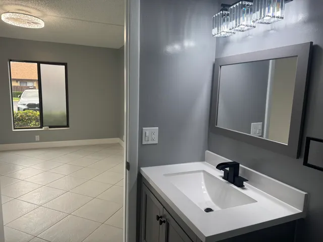 a bathroom with a sink a mirror and a vanity