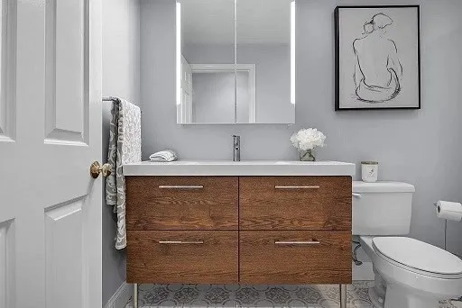 a bathroom with a toilet sink and mirror