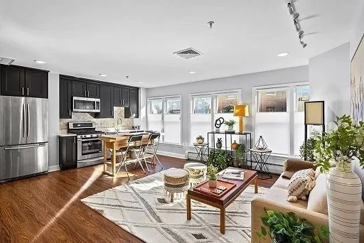a living room with furniture a refrigerator and a stove top oven
