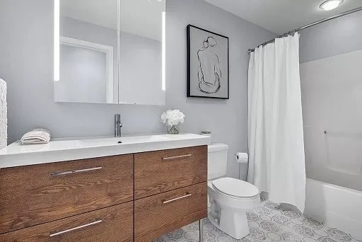 a bathroom with a granite countertop sink a toilet and a shower