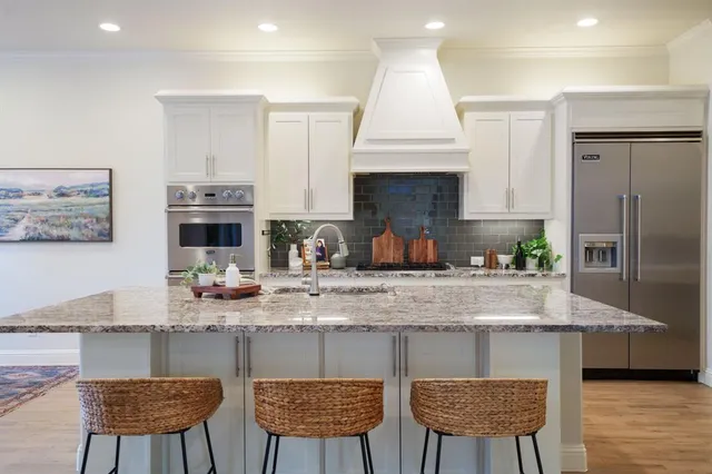 a kitchen with cabinets and chairs