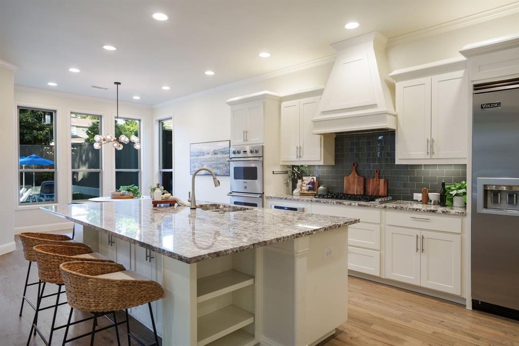 6211 Velasco Avenue Dallas, TX 75214 - Photo 8 of 38 a kitchen with stainless steel appliances granite countertop a sink a stove a refrigerator and a dining table with wooden floor