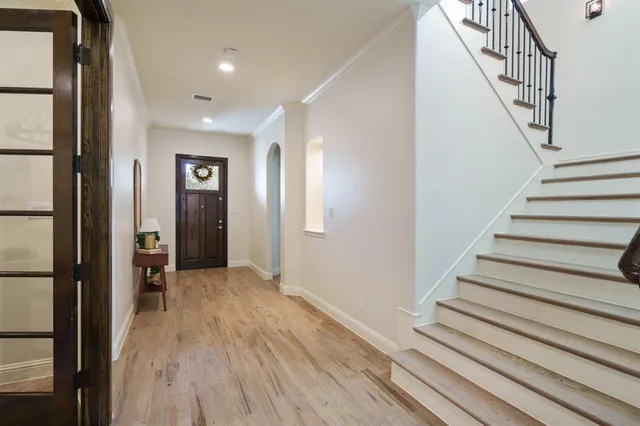 a view of a hallway with wooden floor and staircase