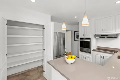 a kitchen with refrigerator and wooden cabinets