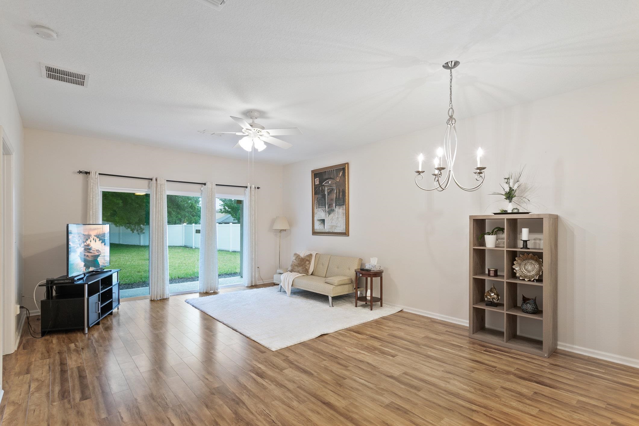 554 Wooded Crossing Circle St. Augustine, FL 32084 - Photo 16 of 43 a living room with furniture and a floor to ceiling window