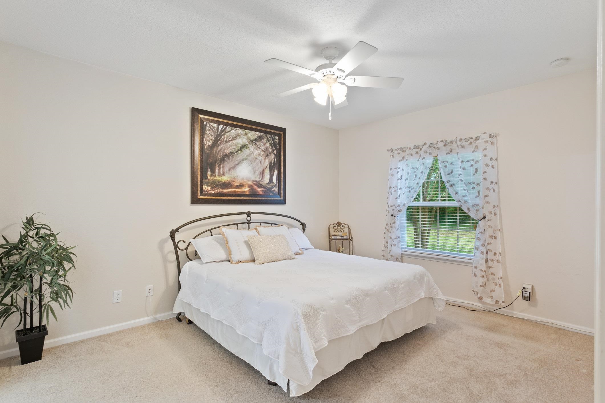 554 Wooded Crossing Circle St. Augustine, FL 32084 - Photo 18 of 43 a bedroom with a bed and a painting on the wall
