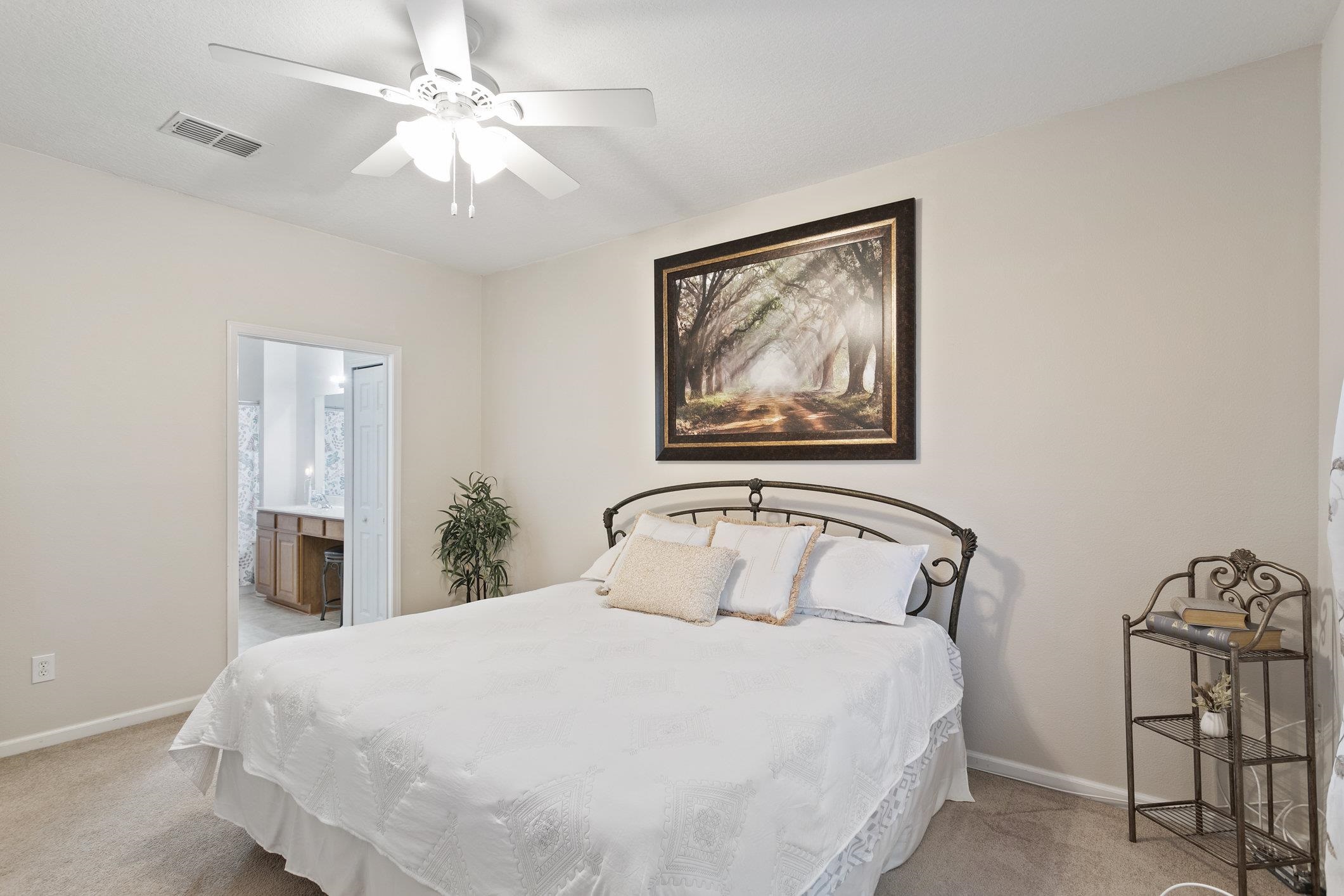 554 Wooded Crossing Circle St. Augustine, FL 32084 - Photo 19 of 43 a bedroom with a large bed and a chandelier