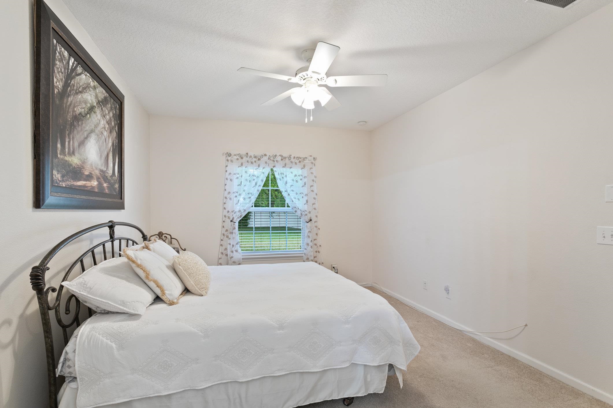 554 Wooded Crossing Circle St. Augustine, FL 32084 - Photo 20 of 43 a bedroom with a bed and a painting on the wall
