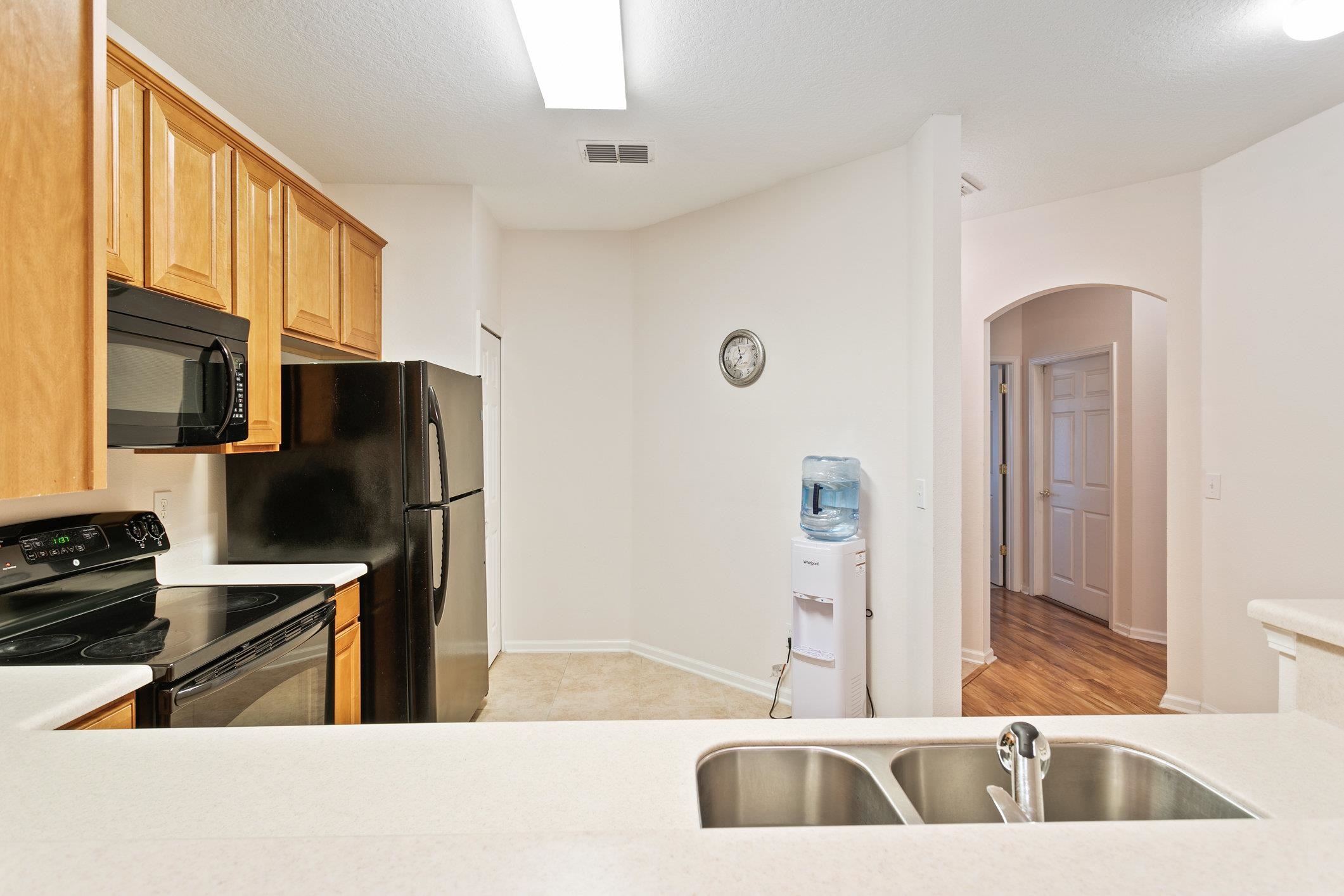 554 Wooded Crossing Circle St. Augustine, FL 32084 - Photo 7 of 43 a kitchen with stainless steel appliances kitchen island granite countertop a sink refrigerator and microwave
