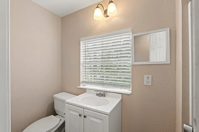a bathroom with a sink a toilet and a window