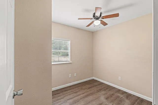 an empty room with a window and a fan